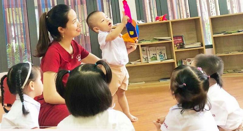 Hình ảnh em bé đang kể chuyện cho gia đình, thể hiện sự mạch lạc trong lời nói