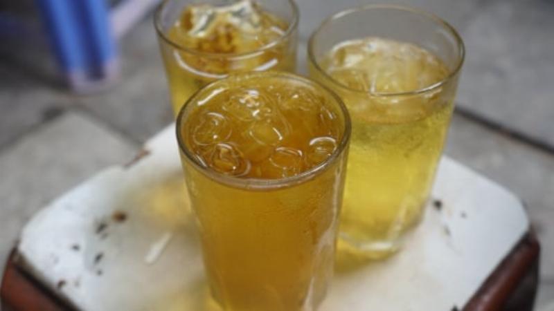 Hình ảnh bà cụ bán hàng nước chè vỉa hè quen thuộc với ấm trà và những chiếc ghế đẩu đơn giản