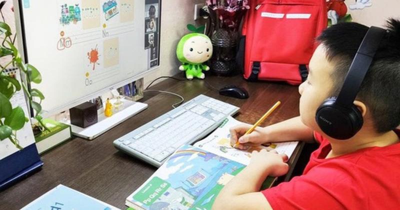 Hình ảnh một học sinh cấp 3 đang ngồi tập trung ôn tập kiến thức cho bài trắc nghiệm tin học lớp 12 bài 7, trước màn hình máy tính mở sách giáo khoa.