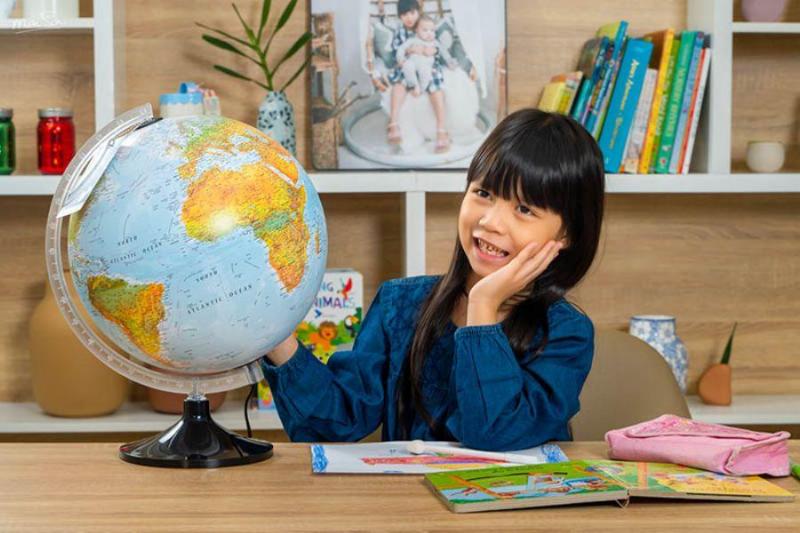 Minh họa trẻ em đang khám phá thế giới trên quả địa cầu hoặc bản đồ lớn