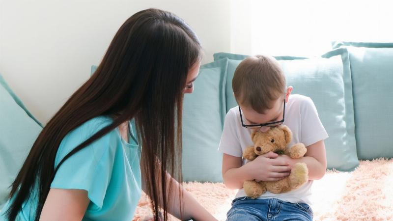 Một đứa trẻ đang nói chuyện cởi mở với phụ huynh trong không gian ấm cúng, thể hiện sự tin tưởng và an toàn
