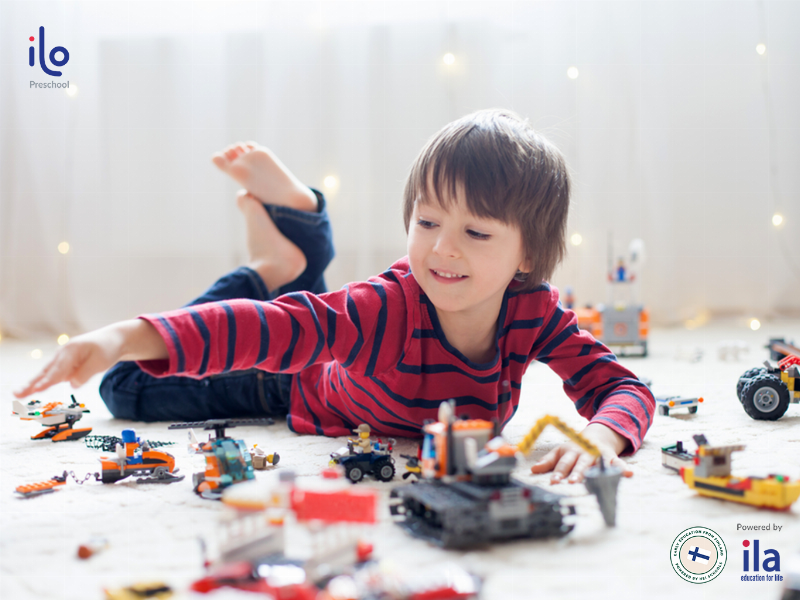 Một người mẹ đang vui vẻ chơi cùng con gái 3 tuổi trên sàn nhà với các khối gỗ, minh họa sự tương tác trong trò chơi cho trẻ 3 tuổi