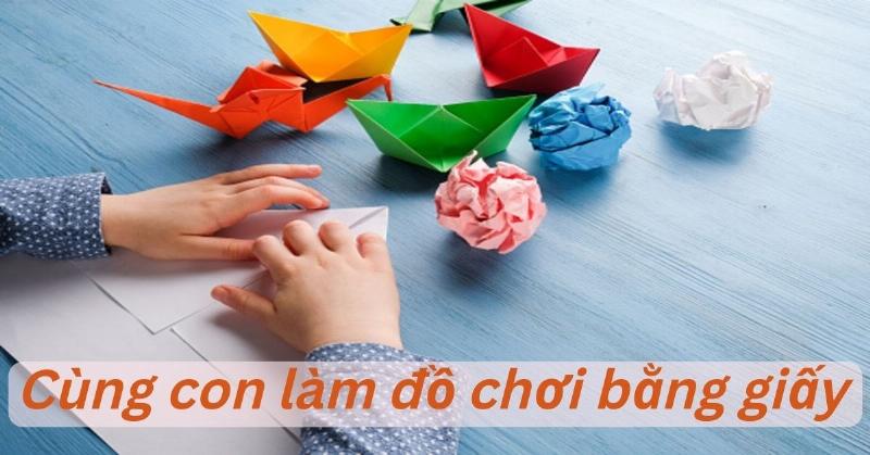 Một bé vui vẻ đang sử dụng các mảnh ghép hình tam giác đều để tạo ra các hình lớn hơn trên sàn nhà
