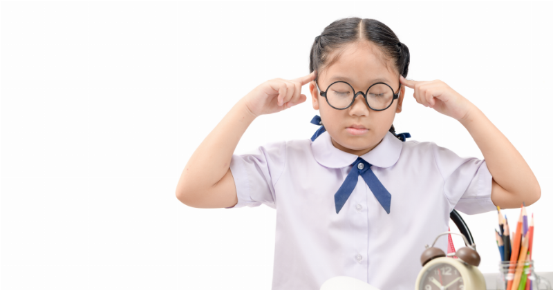 Một học sinh nữ đang làm bài trắc nghiệm sinh học 10 trên giấy, cạnh đồng hồ bấm giờ, thể hiện việc luyện tập quản lý thời gian.